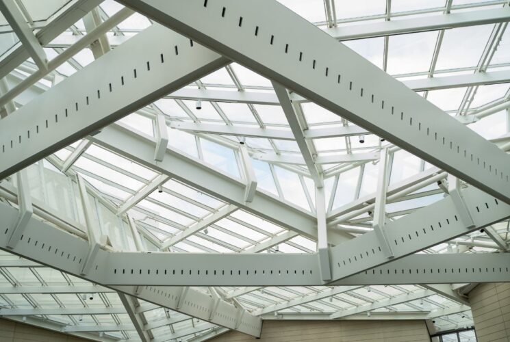 Large white metal supports and windows artistically arranged as roof and ceiling of a museum