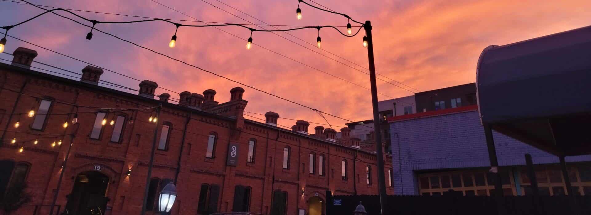 Downtown brick buildings with setting sun clouds in the sky